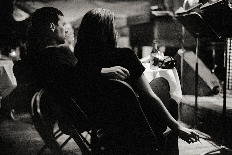 A man and woman sit near the stage.
