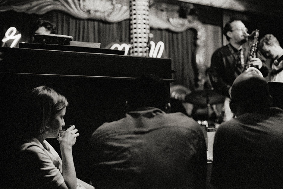 A woman sits near the stage, watching the performance.