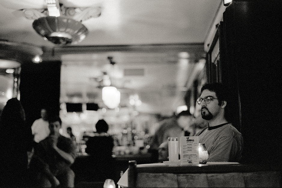 A man with a goatee sits, thinking.