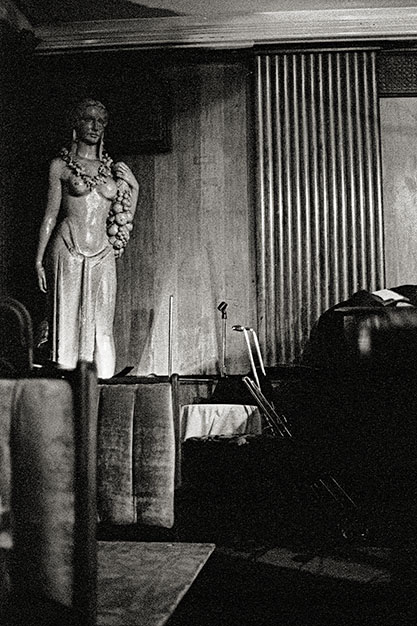 A statue of a woman stands to the left of the stage.