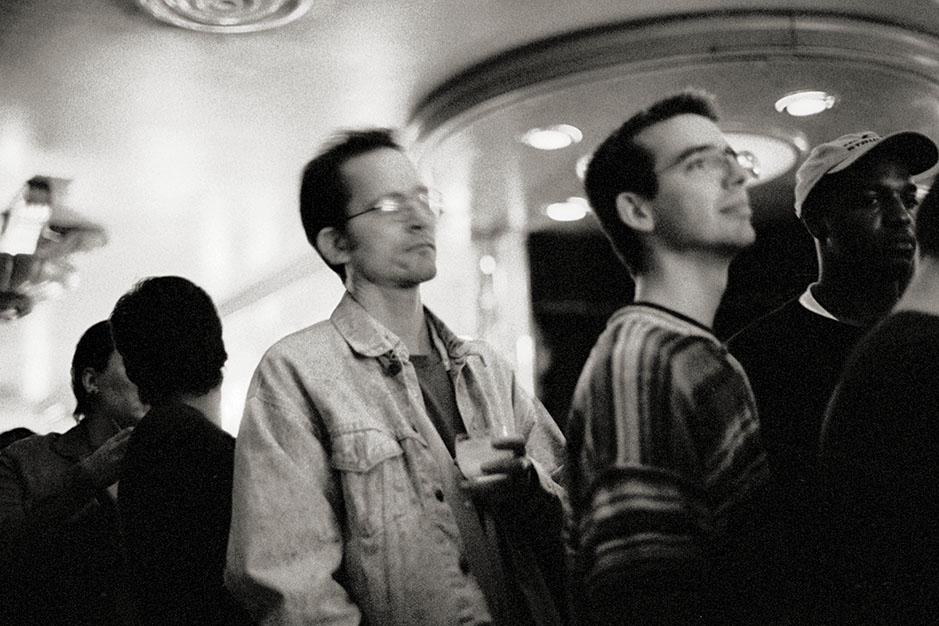A man in a jean jacket listens.