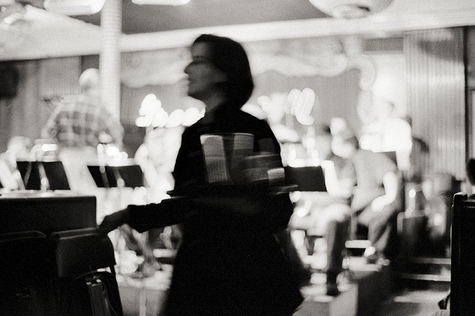 A woman walks past with a tray full of drinks.